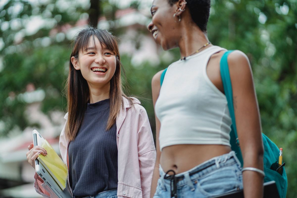 Two students laughing together on campus