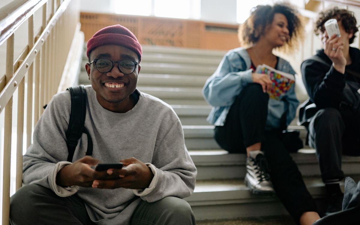 Smiling student sitting on campus steps